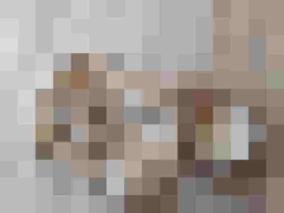 Selbstgemachte Nudeln in einem Holzkorb, umgeben von Mehl und Weizenhalmen.