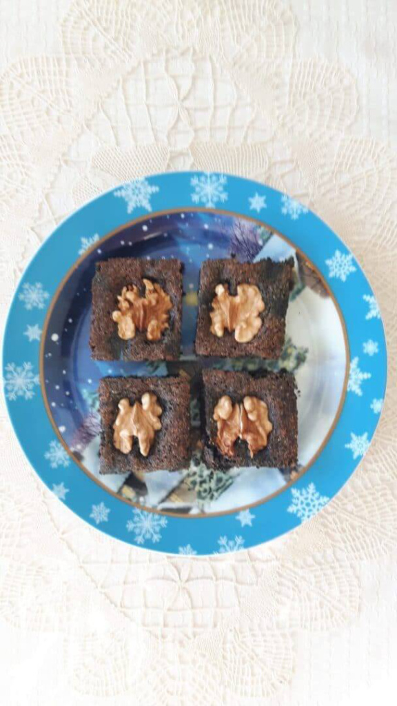 Aronia-Lebkuchenstücke mit Walnüssen auf einem bunten Teller.